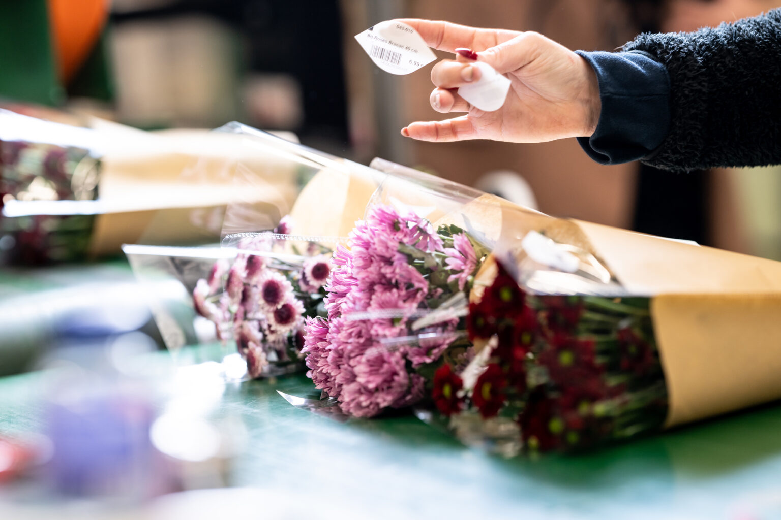 Pose des étiquettes de prix sur les bouquets dans l’atelier Europlantes