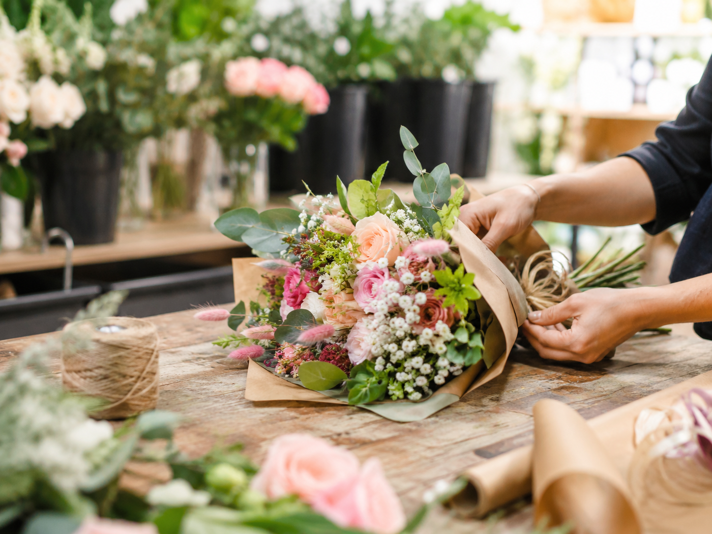 Fleuriste composant un bouquet champêtre dans la bouquetterie Europlantes